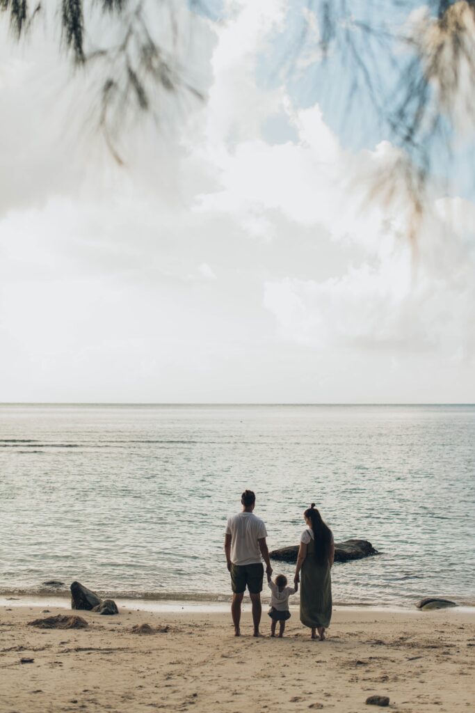 man and woman on beach with child