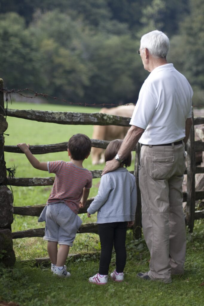 man standing at fence with children