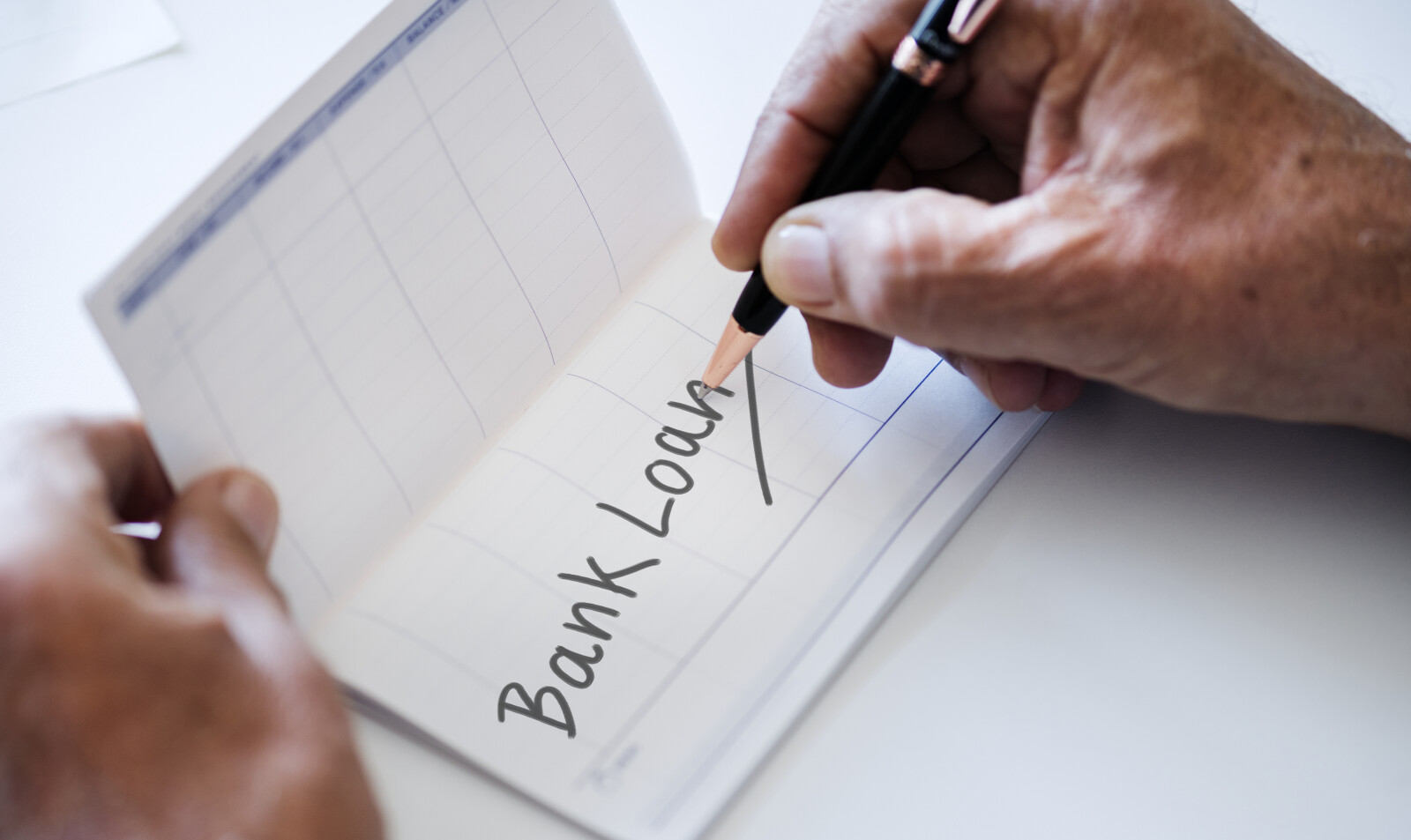person writing the words bank loan on a check register