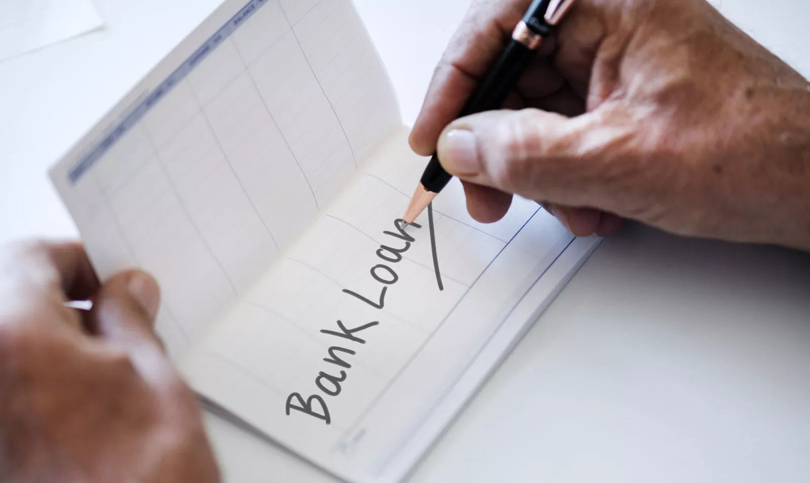 person writing the words bank loan on a check register